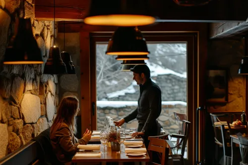 Couple réservant une table dans un restaurant gastronomique en Andorre pour une soirée soignée et maîtriser son budget